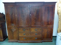 A MAHOGANY BREAKFRONT CABINET, THE CENTRAL DOORS ABOVE TWO SHORT AND TWO LONG DRAWERS ON A PLINTH