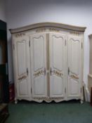 A FRENCH WHITE PAINTED ARMOIRE, THE FOUR DOORS WITH CENTRAL CARVED AND GILT FOLIAGE. W 205 x D 56