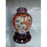 A JAPANESE IMARI JAR, COVER AND WOODEN STAND