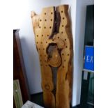 A TREE TRUNK PANEL PIERCED AS A BOTTLE RACK. W 94 x H 244cms.