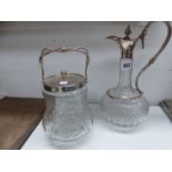 A SILVER PLATE MOUNTED GLASS CLARET JUG AND A SIMILAR BISCUIT BARREL.