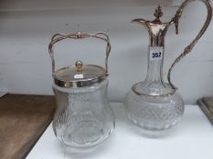 A SILVER PLATE MOUNTED GLASS CLARET JUG AND A SIMILAR BISCUIT BARREL.