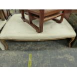 A BUTTONED CREAM UPHOLSTERED OTTOMAN STOOL ON OAK CABRIOLE LEGS