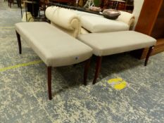 A PAIR OF GREY UPHOLSTERED DOUBLE STOOLS ON MAHOGANY TAPERING SQUARE SECTIONED SABRE LEGS