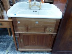 A CERAMIC WASH BASIN WITH GILT MIXER TAPS, THE PINE BASE WITH DRAWERS AND A DOOR BETWEEN FLUTED
