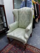 A PALE BLUE DAMASK UPHOLSTERED WING ARMCHAIR
