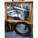 AN EDWARDIAN BEVEL OVAL MIRROR, TOGETHER WITH ANOTHER GILT MIRROR AND A LARGER CONTEMPORARY GILT