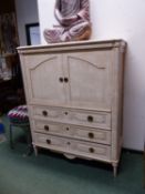 A CREAM PAINTED TV CABINET WITH THREE LONG DRAWERS BELOW ITS DOORS. W 120 x D 56 x H 150cms.