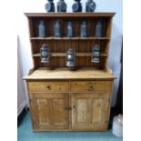 A PINE DRESSER WITH ENCLOSED TWO SHELF BACK, THE BASE WITH TWO DRAWERS AND DOORS. W 125 x D 55 x H