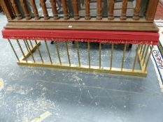 A BRASS CLUB FENDER WITH THE RED UPHOLSTERED SEAT SUPPORTED ON SPIRAL TWIST COLUMNS AND PLINTH FOOT.