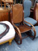 A BENTWOOD ROCKING CHAIR WITH CANED BACK