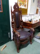 A PAIR OF CARVED MAHOGANY THRONES WITH LEATHER PADDED BACK AND SEATS, THE ARMS WITH LION MASK