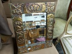 A BEVELLED GLASS RECTANGULAR MIRROR IN ARTS AND CRAFTS COPPER FRAME MODELLED WITH GROUPS OF THREE