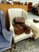 A CREAM UPHOLSTERED WING ARMCHAIR ON MAHOGANY CABRIOLE FRONT LEGS WITH PAD FEET