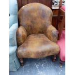 A LEATHERETTE UPHOLSTERED TUB ARMCHAIR ON TURNED LEGS