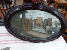 AN OVAL MIRROR IN IMITATION WOOD FRAME