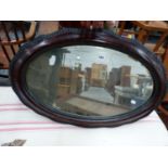 AN OVAL MIRROR IN IMITATION WOOD FRAME