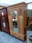 A PINE WARDROBE, THE MIRRORED DOOR OVER A DRAWER AND FLANKED AT THE TOP BY FOLIATE CARVED PANELS