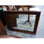 A RECTANGULAR BEVELLED GLASS MIRROR IN AN OAK FRAME