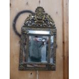 A FOLIATE BRASS FRAMED RECTANGULAR CUSHION SHAPED MIRROR WITH ARCHED CRESTING