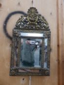 A FOLIATE BRASS FRAMED RECTANGULAR CUSHION SHAPED MIRROR WITH ARCHED CRESTING