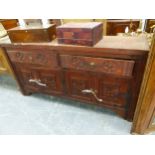 A STAINED PINE SIDE CABINET WITH TWO ROUNDEL CARVED DRAWERS OVER PAIRS OF CUPBOARD DOORS