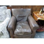 A BROWN LEATHER UPHOLSTERED ARMCHAIR