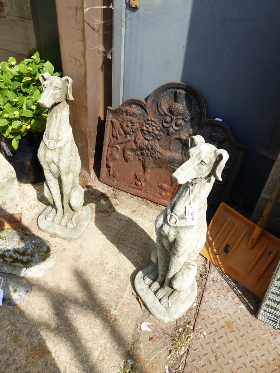 A PAIR OF COMPOSITE STONE DOGS