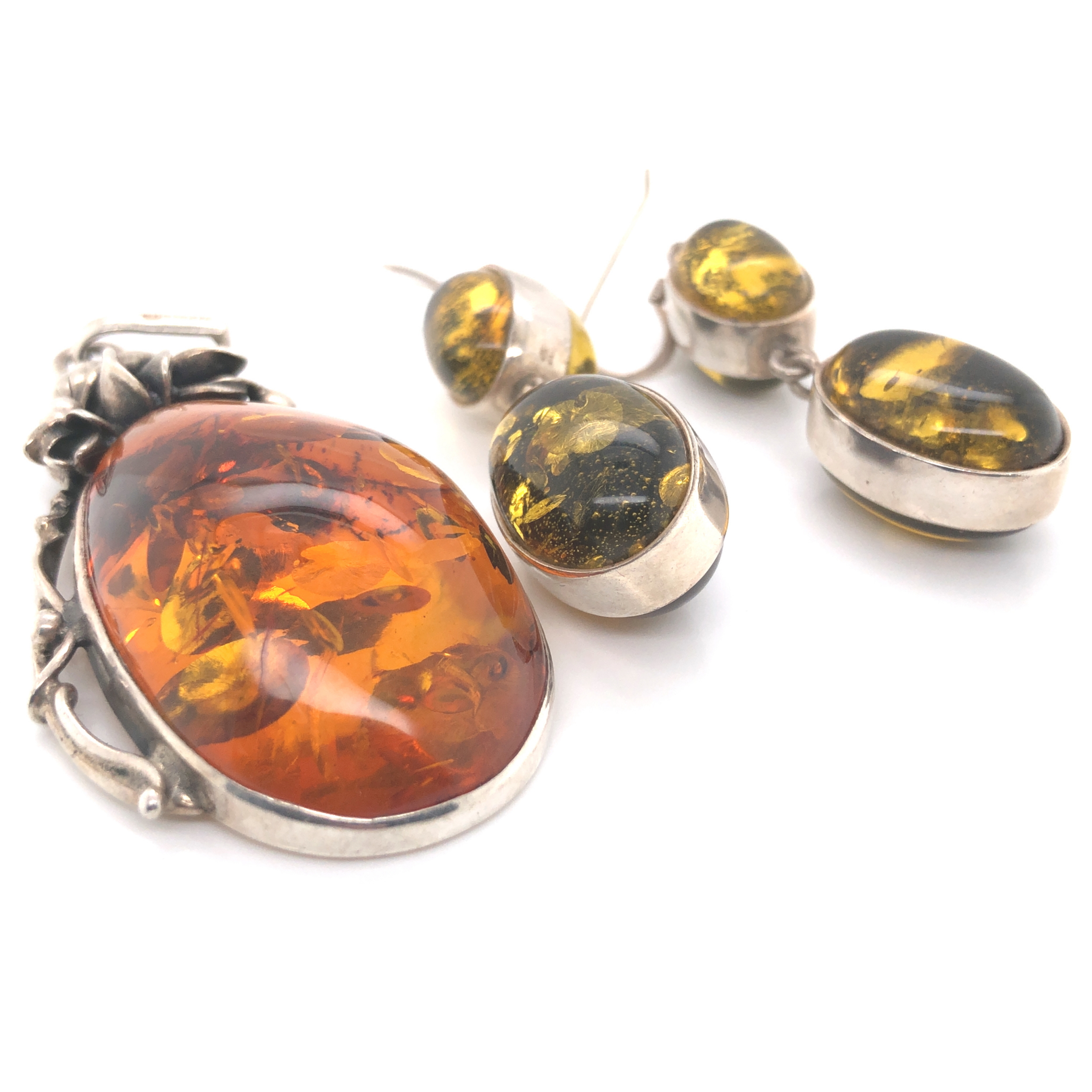 A HALLMARKED SILVER AND AMBER FOLIATE DESIGN DROP PENDANT. LENGTH INCLUDING BAIL 7cms. WEIGHT 17.