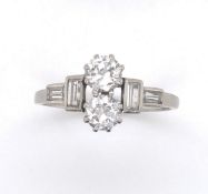 A PLATINUM ART DECO DIAMOND RING. THE TWO OLD CUT PRINCIPLE DIAMONDS FLAKED BY BAGUETTE CUT