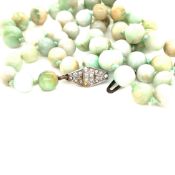 A STRAND OF GRADUATED JADE BEADS COMPLETE WITH A SILVER AND PASTE STONE CLASP. BEAD GRADUATION 8mm