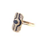 AN 18ct YELLOW GOLD HALLMARKED SAPPHIRE AND DIAMOND PANEL RING. THE CENTRAL BLUE SAPPHIRE AN OVAL