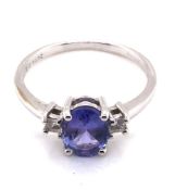 A TANZANITE AND CUBIC ZIRCONIA HALLMARKED 9ct WHITE GOLD DRESS RING. THE OVAL TANZANITE IN A FOUR