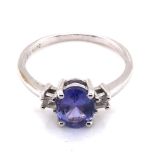 A TANZANITE AND CUBIC ZIRCONIA HALLMARKED 9ct WHITE GOLD DRESS RING. THE OVAL TANZANITE IN A FOUR