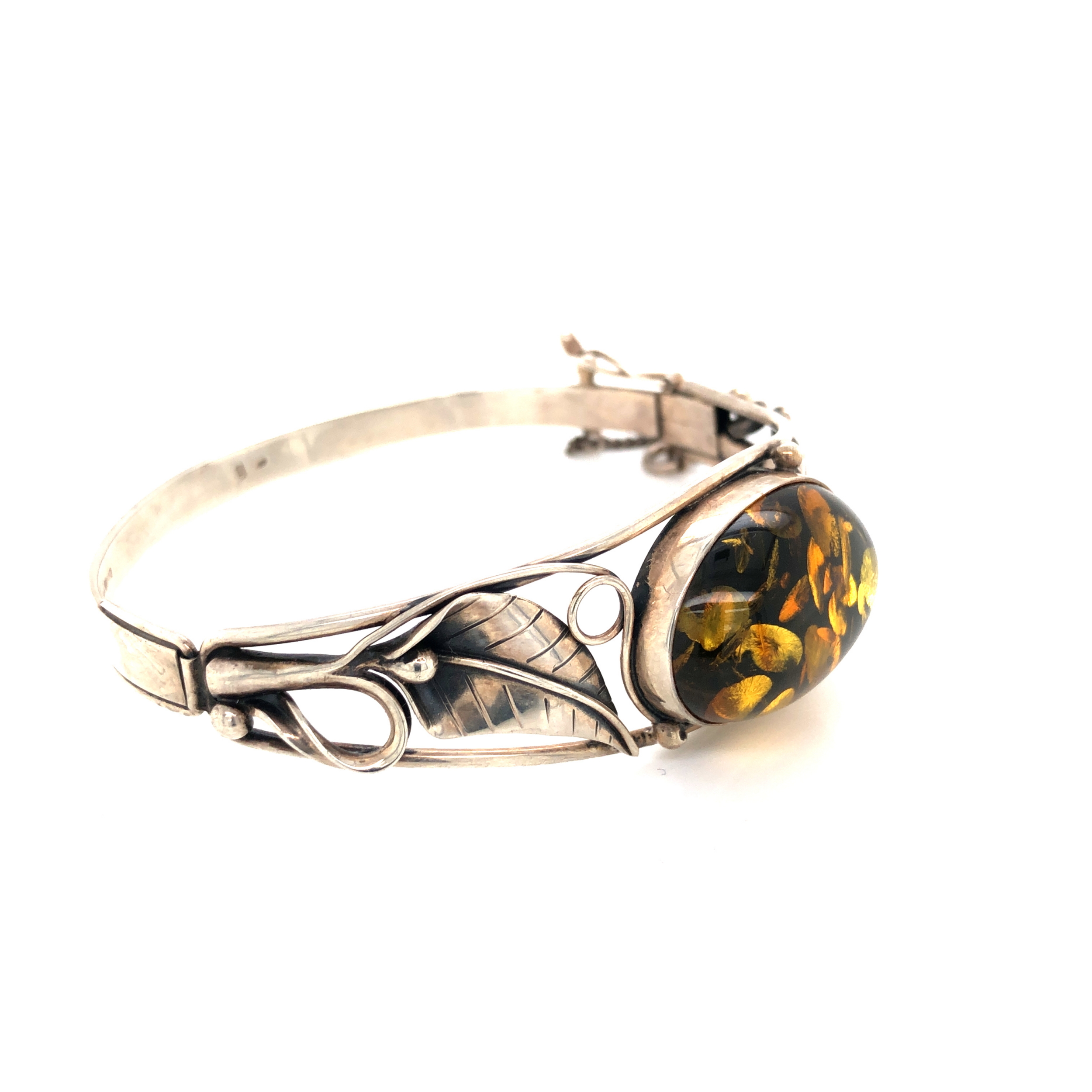 AN AMBER AND SILVER HALLMAKRED ART NOUVEAU STYLE HINGED BANGLE. THE OVAL AMBER IN A FOLIATE - Image 2 of 2