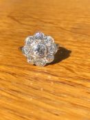 AN ANTIQUE PLATINUM AND OLD CUT DIAMOND DAISY FLOWER CLUSTER. THE CENTRE STONE 0.85cts, THE EIGHT