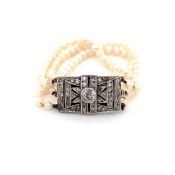 A VINTAGE CULTURED PEARL THREE STRAND GRADUATED BRACELET ON A SILVER PASTE SET CLASP STAMPED 935.