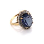 A 9ct YELLOW GOLD OVAL HALLMARKED FANCY CUT PURPLISH / BLUE QUARTZ AND DIAMOND SET CLUSTER RING.