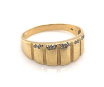 A GENTS DIAMOND SET GRADUATED PANEL RING IN YELLOW GOLD. HALF THE BORDER SET WITH TEN SMALL