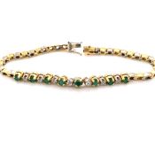 AN 18ct HALLMARKED YELLOW AND WHITE GOLD EMERALD AND DIAMOND LINE BRACELET. THE FIFTEEN