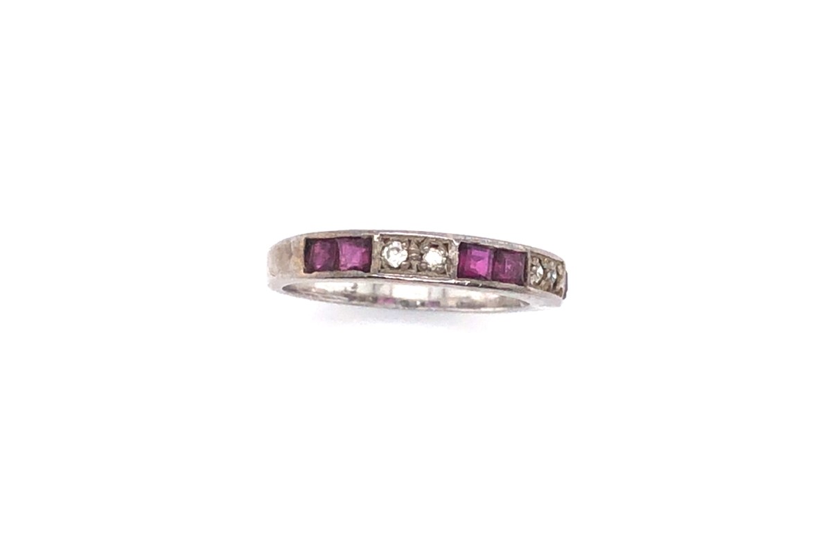 A VINTAGE RUBY AND CUBIC ZIRCONIA CHANNEL SET HALF ETERNITY RING SHANK STAMPED 925 AND ASSESSED AS