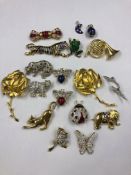 A COLLECTION OF SIXTEEN STONE SET, ENAMEL AND OTHER COSTUME BROOCHES AND TWO ENAMEL STAR DECORATED