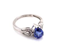 AN 18ct WHITE GOLD HALLMARKED TANZANITE AND DIAMOND RING. THE PEAR CUT TANZANITE IN A RAISED THREE