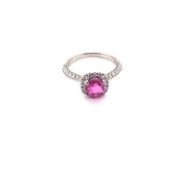 A HALLMARKED PLATINUM 950, PINK SAPPHIRE AND DIAMOND HALO SET RING. THE OVAL CUT PINK SAPPHIRE