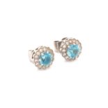 A PAIR OF VINTAGE BLUE ZIRCON AND DIAMOND STUD EARRINGS. THE ROUND BRILLIANT CUT BLUE ZIRCONS IN