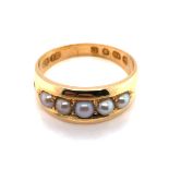 A VICTORIAN 18ct GOLD AND PEARL RING. THE FIVE PEARLS GRADUATED AND INSET. DATED 1879 LONDON.
