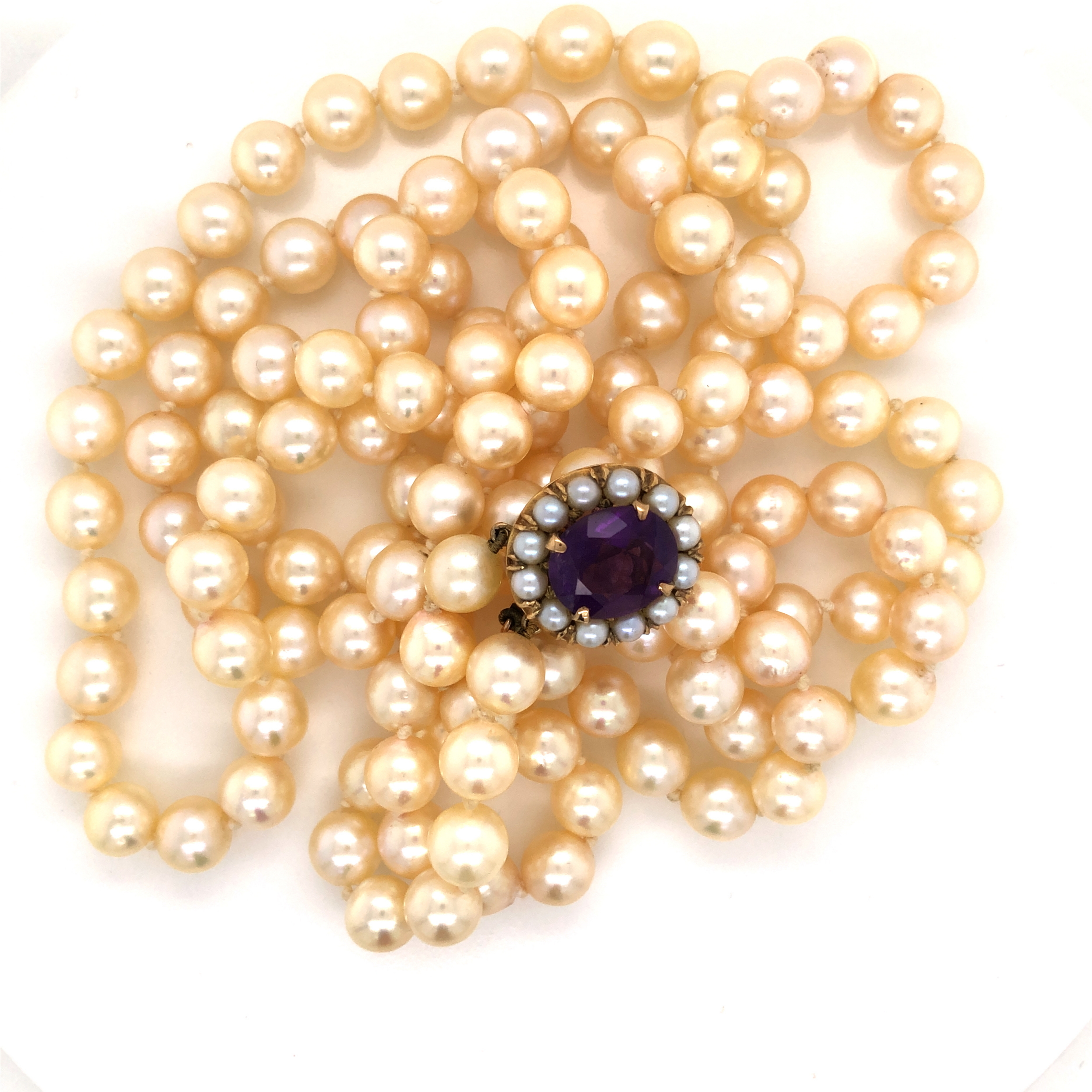 A MATINEE DOUBLE ROW OF CREAM COLOURED KNOTTED CULTURED PEARLS ON A 9ct STAMPED GOLD CLASP SET