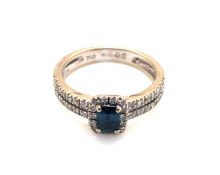 AN 18ct WHITE GOLD HALLMARKED SAPPHIRE AND DIAMOND HALO SET RING WITH SPLIT DIAMOND SET SHOULDERS.