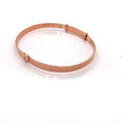 A LADIES SILVER AND ROSE GOLD PLATED EXPANDING BANGLE WITH A HEART MOTIF. WEIGHT 7.03grms.