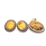 A PAIR OF AMBER AND MARCASITE STUD EARRINGS, TOGETHER WITH A OVAL AMBER RUB OVER SET PENDANT. THE